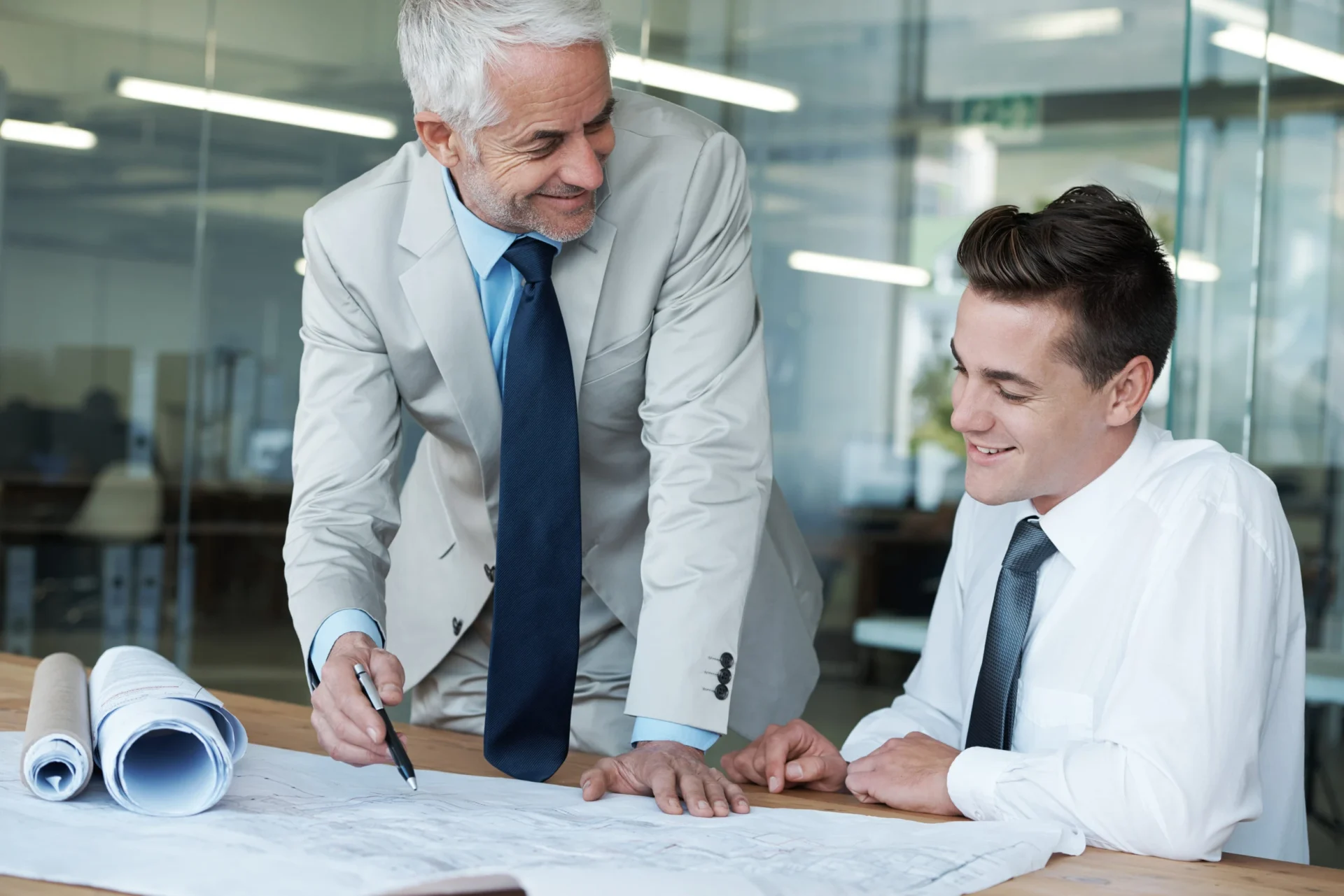 Business mentor reviewing plans with a startup founder, representing preparation and strategic guidance before seeking investor funding.