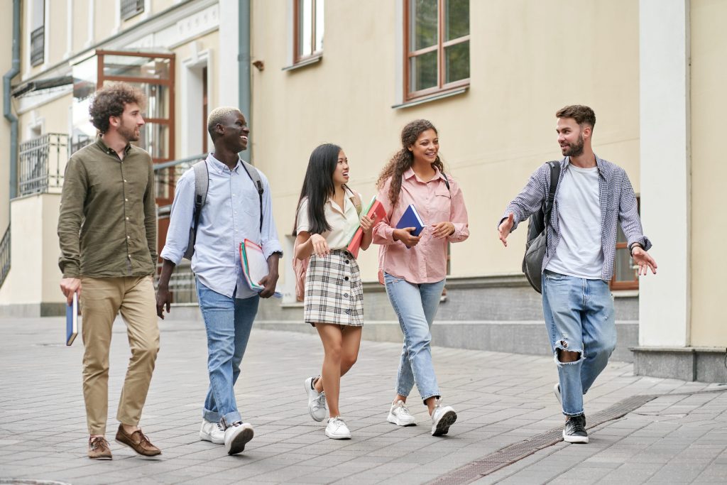 Diverse college students walking together across a university campus, representing a safe and connected higher education environment supported by modern campus safety technology.